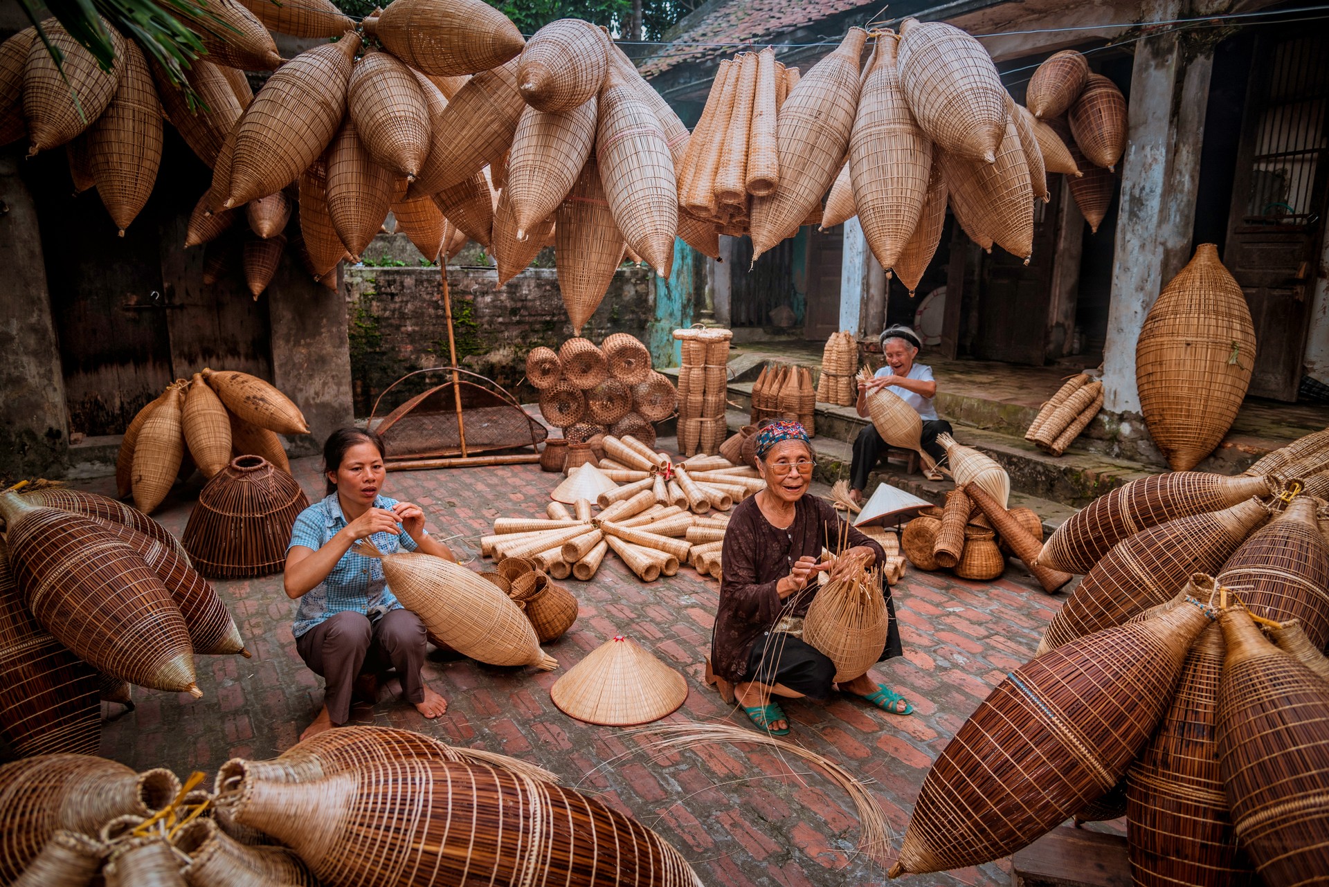 Vietnamese fishermen are doing basketry for fishing equipment at morning in Thu Sy Village, Vietnam.